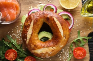 Assorted freshly baked bagels with various toppings and fillings on a wooden board, highlighting the diversity and appeal of bagels worldwide