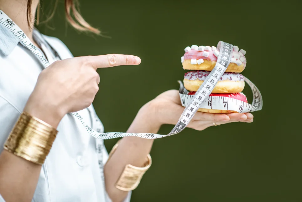 Assorted donuts on a plate showcasing different flavors and toppings, highlighting the variety and appeal of this popular treat while considering their caloric content.