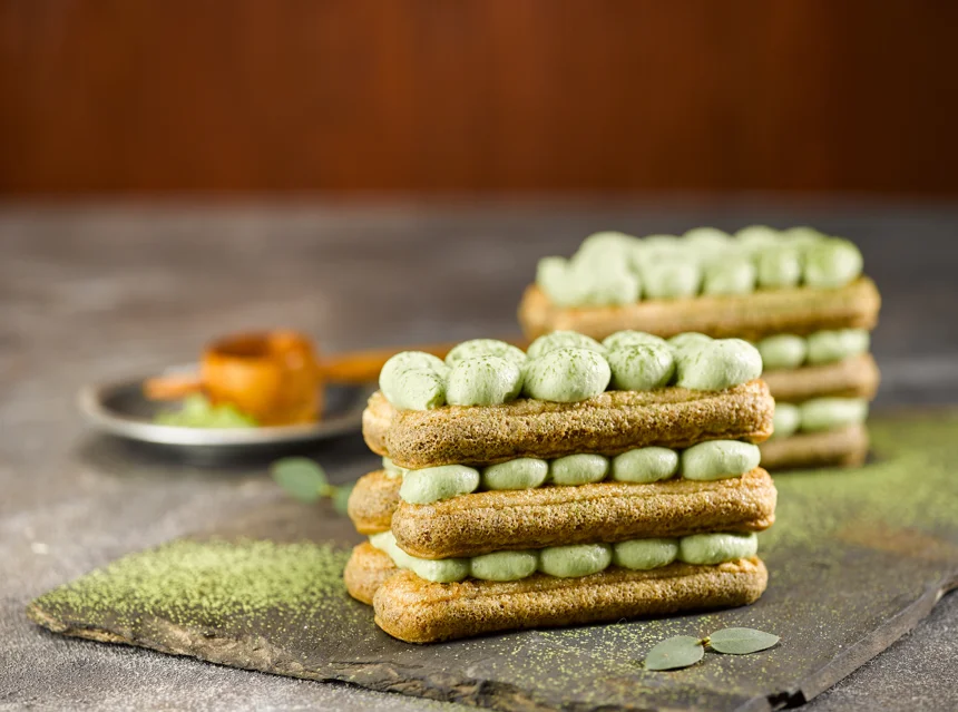 Layered matcha tiramisu in a clear dish showing green tea and mascarpone layers