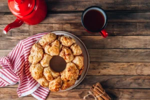 A plate of warm monkey bread with pieces being pulled apart, showcasing the soft, fluffy interior.