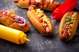 Delicious air fryer hot dogs with a golden, crispy exterior and juicy interior, served with a side of toasted buns and a variety of toppings.