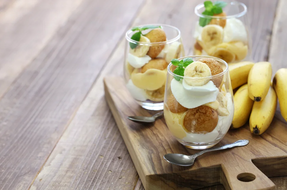 Layered banana pudding in a glass dish, prepared the night before, showcasing its creamy texture and fresh banana slices with a golden meringue topping.