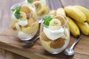 Layered banana pudding in a glass dish, prepared the night before, showcasing its creamy texture and fresh banana slices with a golden meringue topping.