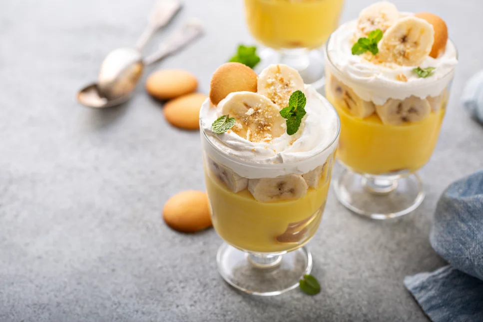 "Ingredients laid out for Patti Labelle's banana pudding recipe, including vanilla pudding mix, sweetened condensed milk, heavy cream, vanilla wafers, and ripe bananas.