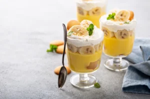 "Ingredients laid out for Patti Labelle's banana pudding recipe, including vanilla pudding mix, sweetened condensed milk, heavy cream, vanilla wafers, and ripe bananas.