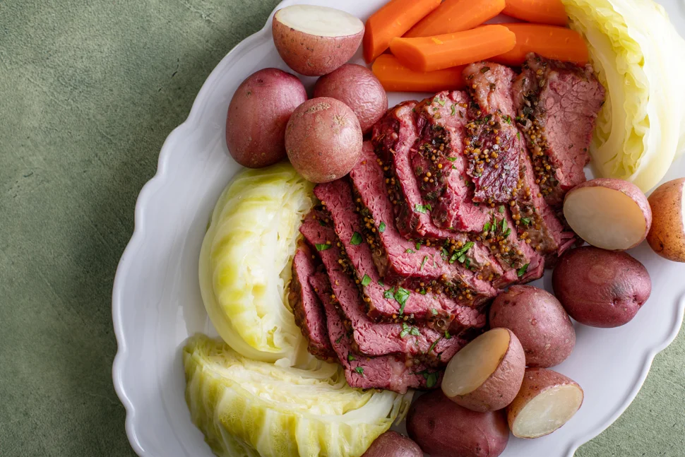 Crock pot filled with savory corned beef and vibrant vegetables, showcasing the rich, tender meal prepared for a comforting family dinner.