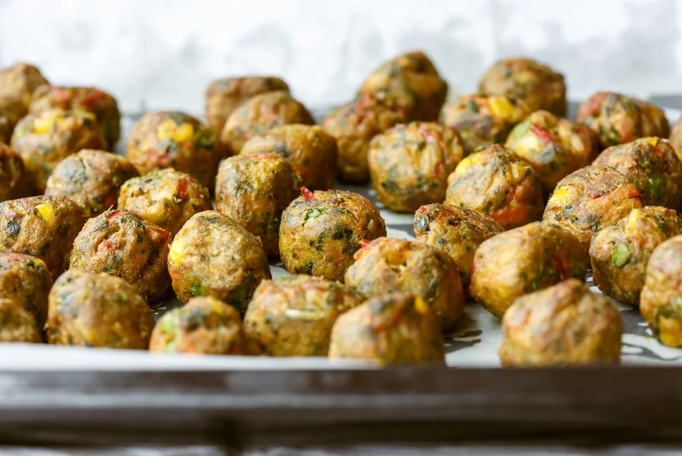 Close-up of juicy, well-seasoned meatballs on a plate, garnished with fresh parsley, highlighting the rich flavors and textures achieved through proper seasoning and cooking techniques.