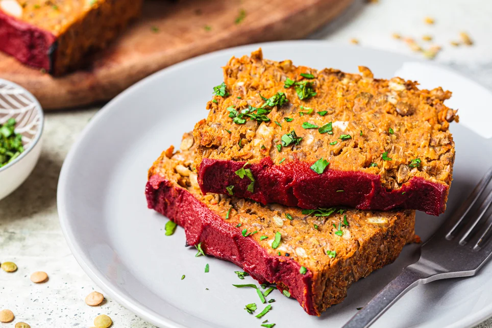 Healthy homemade meatloaf served on a plate with fresh vegetables