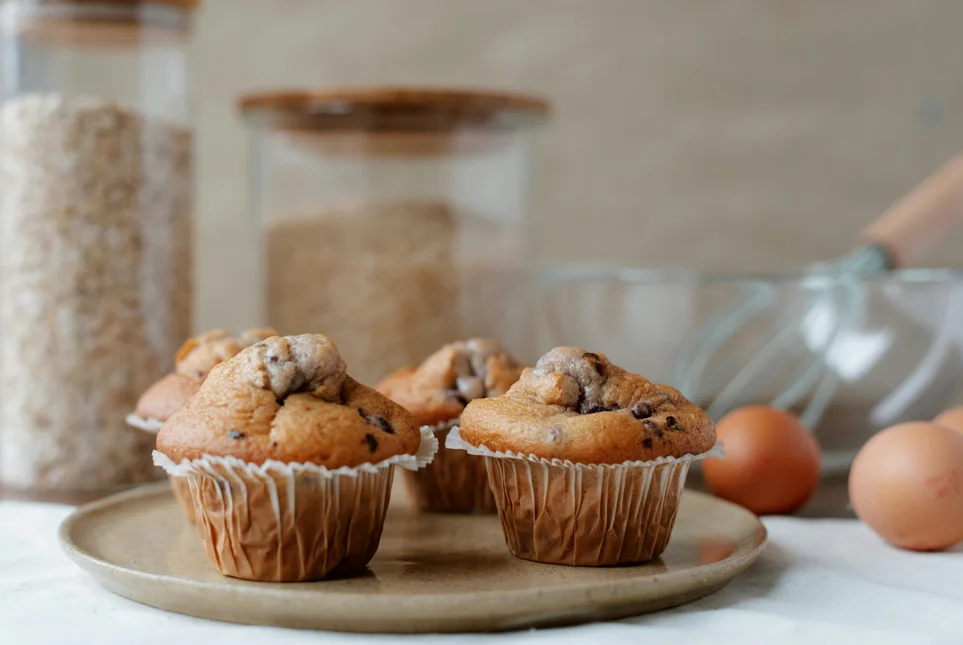 Homemade pumpkin chocolate chip muffins cooling on a wire rack, ready to be enjoyed with a cup of coffee.