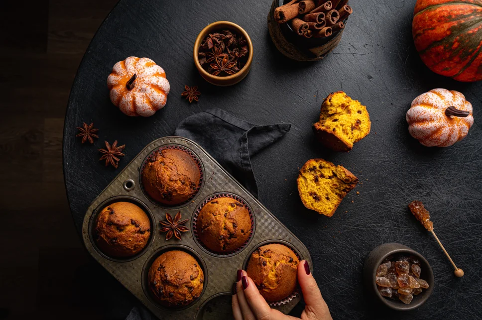 Freshly baked pumpkin muffins on a cooling rack, showcasing their golden tops and moist texture, embodying the essence of fall baking.