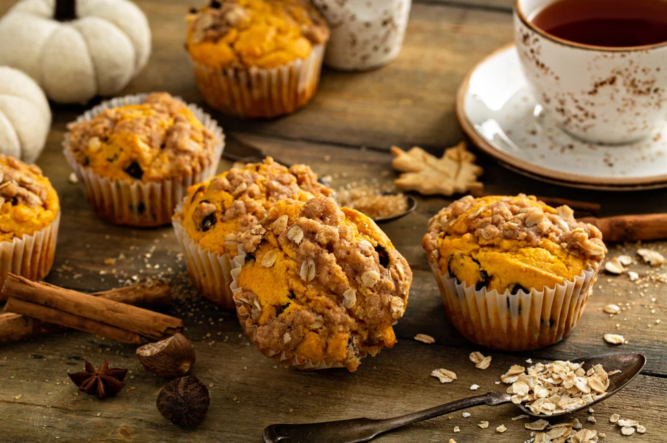 Assorted freshly baked pumpkin muffins on a cooling rack, showcasing the warm, inviting colors and textures of fall baking ingredients.