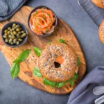 Vegan bagel topped with avocado, tomatoes, and sesame seeds, representing delicious and ethical options for vegans.