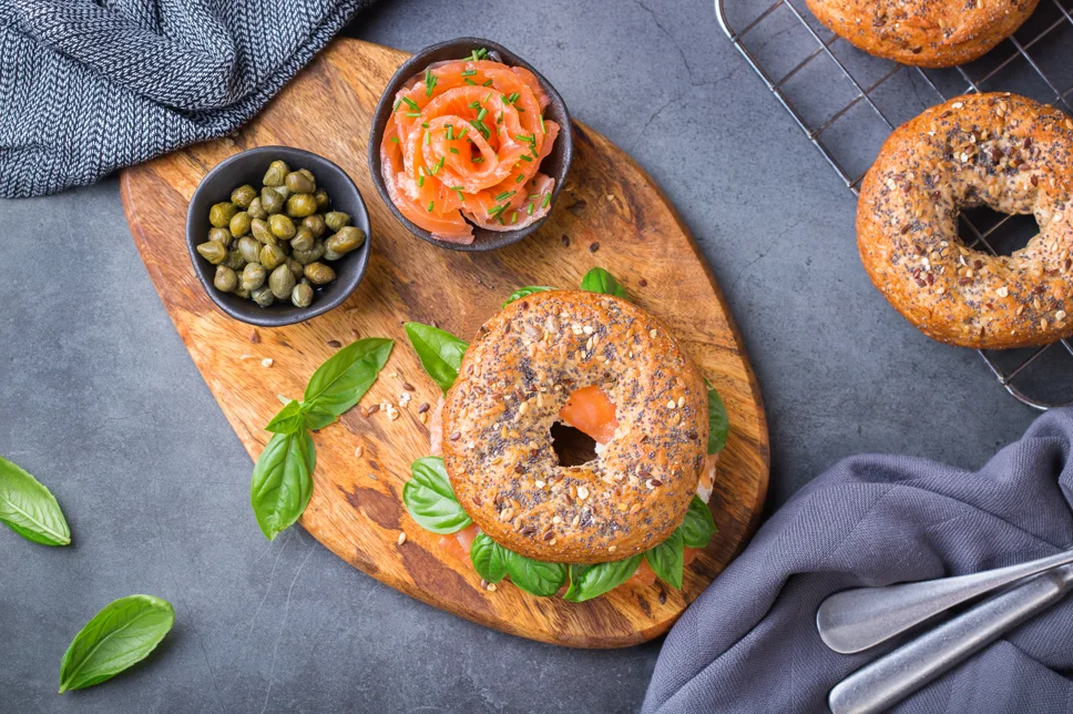 Vegan bagel topped with avocado, tomatoes, and sesame seeds, representing delicious and ethical options for vegans.