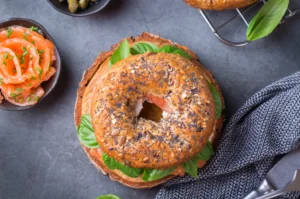 Vegan bagel topped with avocado, tomatoes, and sesame seeds, representing delicious and ethical options for vegans.